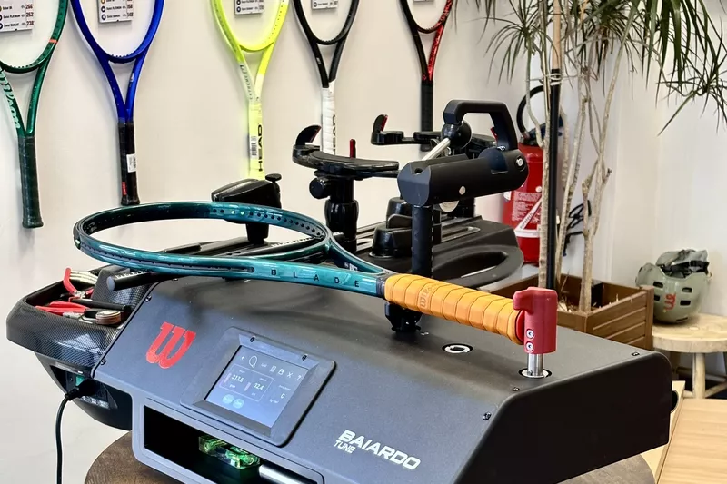 Machine de mesure devant le mur de raquettes de l’atelier